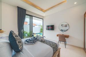 a bedroom with a bed and a desk and a mirror at Villa Kusuma 3 Seminyak in Badung