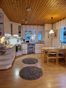 Villa Karhurinne في ليمبالا: مطبخ مع طاولة وغرفة طعام