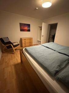 una camera da letto con un letto e una sedia di "An der alten Mühle 2" - Fewo 80qm, zentral gelegen, zwei Schlafzimmer, Südterrasse und Wallbox a Bad Bentheim