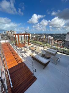 a balcony with tables and chairs on a building at Melhores Flats - Elegante a 5 min do mar de Tambaú in João Pessoa