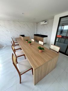 a long wooden table and chairs in a room at Melhores Flats - Elegante a 5 min do mar de Tambaú in João Pessoa +20 photos
