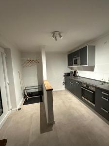 una cucina con armadi neri e bancone di "An der alten Mühle 2" - Fewo 80qm, zentral gelegen, zwei Schlafzimmer, Südterrasse und Wallbox a Bad Bentheim