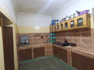 a kitchen with wooden cabinets and a counter top at Auberge le calme restaurante in Bou Drarar