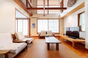 a living room with a couch and a tv at SEBARI casa vacation rental in Kushima
