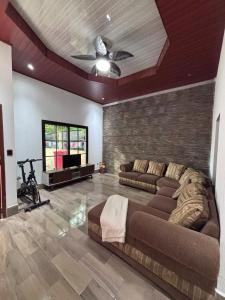 uma sala de estar com um sofá e um ventilador de teto em Casa Amelia, 5 minutes from the airport em Flores