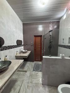 um banheiro com chuveiro, pia e banheira em Casa Amelia, 5 minutes from the airport em Flores