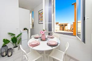 uma sala de jantar branca com uma mesa e cadeiras brancas em 3P Monaco avec parking em Saint-Antoine