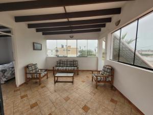 un soggiorno con due sedie e un tavolo di Casa con Piscina privada y a pasos de la playa a Lurín