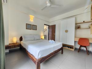 Premium 1BHK Beachside Apartment - Pool, Full Kitchen & Balcony, Candolim في كاندوليم: غرفة نوم بها سرير ومكتب وكرسي +23 صورة