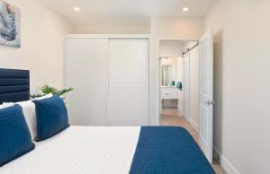 una camera bianca con un letto blu e bianco di Walk to Mullins Beach Ground Floor Pool Fast WiFi a Saint Peter Altre 21 foto