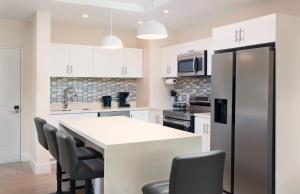 una cucina con armadi bianchi e piano di lavoro bianco di Walk to Mullins Beach Ground Floor Pool Fast WiFi a Saint Peter