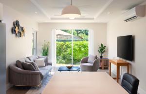 un soggiorno con due sedie e un tavolo di Walk to Mullins Beach Ground Floor Pool Fast WiFi a Saint Peter