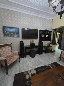 Kelmatic Guesthouse on 5th Ave في روديبورت: غرفة معيشة مع أريكة وتلفزيون بشاشة مسطحة