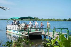 a group of people getting on a boat on a dock at Apart hotel Barra First in Rio de Janeiro