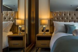 a bedroom with a bed and two night stands with lamps at Mansio Suites Basinghall in Leeds