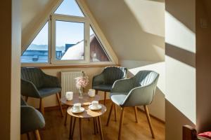 una stanza con tre sedie e un tavolo e una finestra di Pokoje Pod Tatrami & Apartament Biały Dunajec a Zakopane