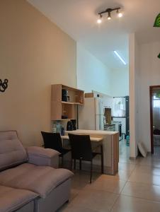 a kitchen and living room with a couch and a table at Ótima casa Jardim do Éden - Tramandaí, poucos passos do mar! in Tramandaí