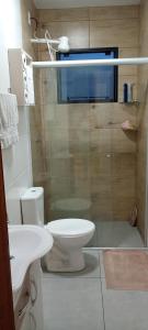 a bathroom with a toilet and a glass shower at Ótima casa Jardim do Éden - Tramandaí, poucos passos do mar! in Tramandaí +26 photos