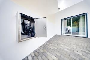 een kamer met een groot raam in een witte muur bij C&A Guest House in Furnas