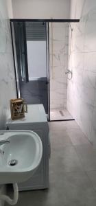 een badkamer met een witte wastafel en een douche bij PERLA 9- Golem Best apartment in Golem