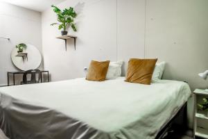a bedroom with a large white bed with two pillows at Cosmic Leopard in Cape Town