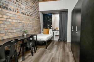 a room with a brick wall and a table and chairs at Cosmic Leopard in Cape Town
