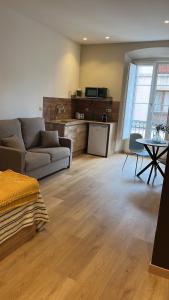 a living room with a couch and a table at Alojamientos Boutique Ribadesella in Ribadesella