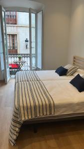 a large bed in a room with a large window at Alojamientos Boutique Ribadesella in Ribadesella