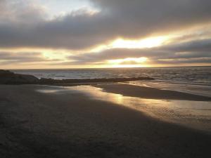a sunset on a beach with the ocean at 4 person holiday home in Hjørring-By Traum in Lønstrup
