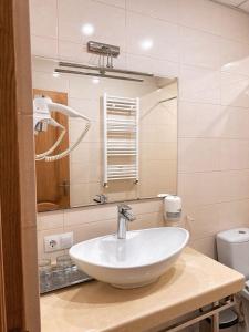 ソロカにあるCentral Hotelの白い洗面台と鏡のあるバスルーム