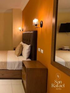 克雷塔罗Hotel San Rafael的有两张床和一面镜子的酒店房间