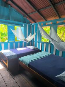 カプルガナにあるLa Bohemia Capurganáのハンモックが吊るされた部屋にベッドが2つ