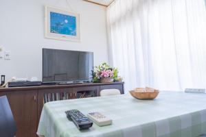 uma sala com uma mesa com um controle remoto e uma televisão em Kyoto Fushimi Yado - Vacation STAY 19114 em Quioto