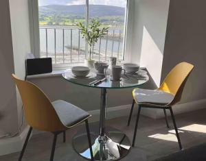 a table and chairs in a room with a window at Aurora House 2B Warrenpoint in Newry