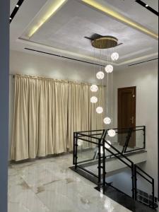 una sala da pranzo con un tavolo e un lampadario di Villa Noir a Islamabad Altre 6 foto