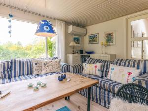 a living room with couches and a wooden table at Secluded Spa Retreat - By Traum Ferienwohnungen in Lønstrup
