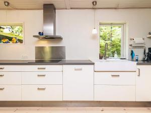 a kitchen with white cabinets and a sink at Secluded Spa Retreat - By Traum Ferienwohnungen in Lønstrup +21 photos