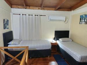 a bedroom with two beds and a table and a window at Raíces Cataratas in Puerto Iguazú +37 photos