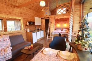 een woonkamer met een kerstboom in een blokhut bij 3 Peaks Houses - Domki Całoroczne in Sokołowsko