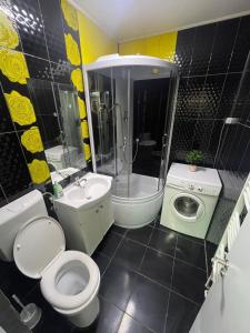 ein Badezimmer mit Toilette, Waschbecken und Waschmaschine in der Unterkunft LCB Apartments P Victoriei in Ploieşti + 13 Fotos