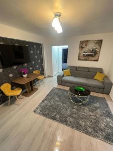 ein Wohnzimmer mit Sofa und Tisch in der Unterkunft LCB Apartments P Victoriei in Ploieşti