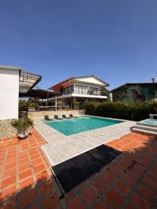 una piscina davanti a una casa di Hotel Campestre Alma Nativa a Calarcá