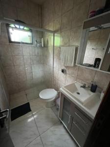 Un baño con ducha, lavabo e inodoro. en Ampla casa em Porto Belo com fácil acesso à Zimbros, en Porto Belo 13 fotos más