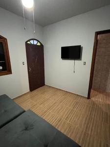 Una sala de estar con un televisor de pantalla plana en una pared. en Ampla casa em Porto Belo com fácil acesso à Zimbros, en Porto Belo