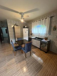 cocina con mesa y sillas azules en una habitación en Ampla casa em Porto Belo com fácil acesso à Zimbros, en Porto Belo