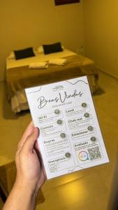 a person holding a sign in front of a bed at Pousada Na Serra Ubajara in Ubajara