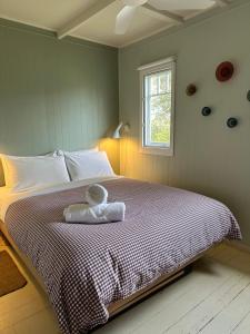 Un dormitorio con una cama con un osito de peluche encima. en Little Oneroa Beach Bach, en Waiheke Island