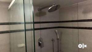 a shower with a glass door in a bathroom at Charis Villa and Guest house 5bed 4bath in kunnamkulam in Kunnamkulam +15 photos