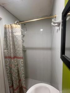 a bathroom with a toilet and a shower curtain at Aparta estudio Santa Marta in Santa Marta