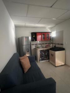 a living room with a blue couch and a kitchen at Aparta estudio Santa Marta in Santa Marta